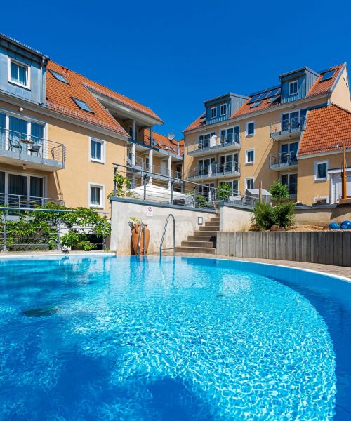 Ansicht des Steiger Apparthotel Bad Schandau mit Poolbereich und Liegeflächen